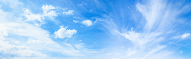 Blue sky with scattered white clouds and wispy cirrus clouds spread across the horizon.